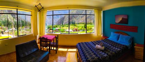 奥兰太坦波Mountain View House Ollantaytambo的一间卧室配有一张床、一把椅子和窗户。