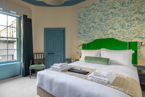 爱丁堡Eleven Stafford Street Townhouse的一间卧室配有一张大床和绿色床头板