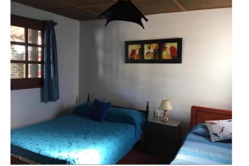 阿加斯杜尔斯Casa Los Hibiscos - Aguas Dulces的一间卧室设有蓝色的床和窗户。
