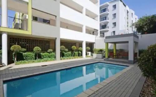 约翰内斯堡Apartment in Sandton, Rivonia的大楼前的游泳池