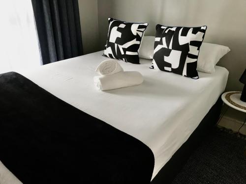 约翰内斯堡Apartment in Sandton, Rivonia的一张黑白床,带两条毛巾
