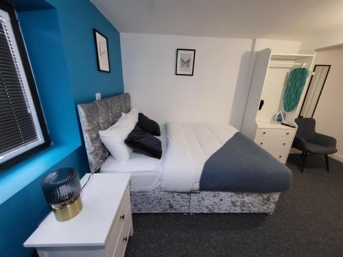 诺丁汉Premier Studios Nottingham - Tring Vale的一间卧室设有一张床和蓝色的墙壁