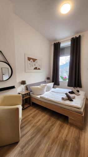 杜伊斯堡ELENA flat Orchidee Duisburg Zentrum的卧室配有床、椅子和窗户。