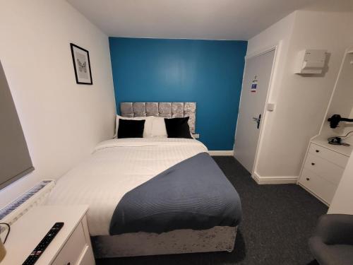 诺丁汉Stay Sleep Rest - Tring Vale的一间卧室设有一张蓝色墙壁的大床