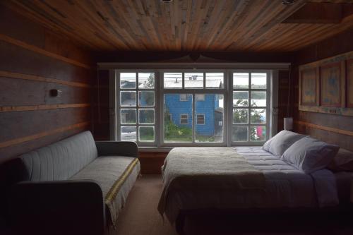 卡斯特鲁Estación Hostel的一间卧室配有一张床、一张沙发和一个窗口