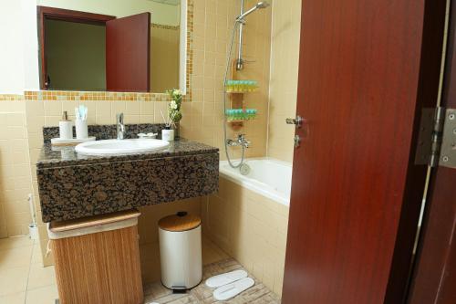 迪拜Pure Sand - Luxury Hostel JBR Dubai的浴室配有盥洗盆和浴缸。