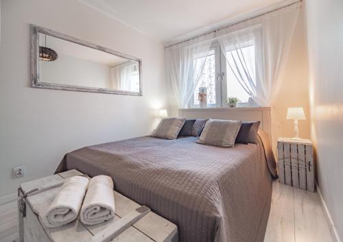 格丁尼亚Bianco Apartament的卧室配有一张壁挂镜子的床