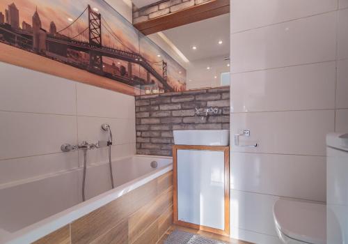 格丁尼亚Bianco Apartament的带浴缸、卫生间和盥洗盆的浴室