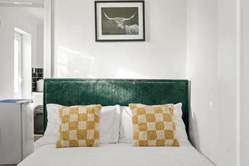 Buckinghamshire1 bedroom flat Aylesbury, Private Parking, Fowler rd的一张带绿色床头板的白色床和两个枕头