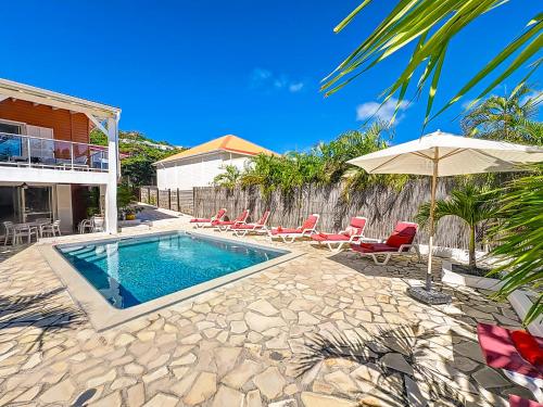 东方湾Villa Caribbean Star, 5 min walk from the beach的房屋旁的游泳池配有椅子和遮阳伞