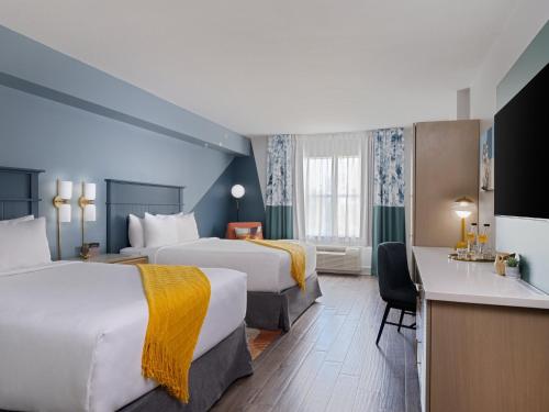 萨拉索塔voco Sarasota, an IHG Hotel的酒店客房配有两张床和一张书桌
