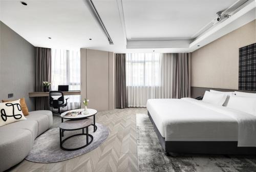 义乌义乌巴里岛雅庭酒店的酒店客房,配有床和沙发