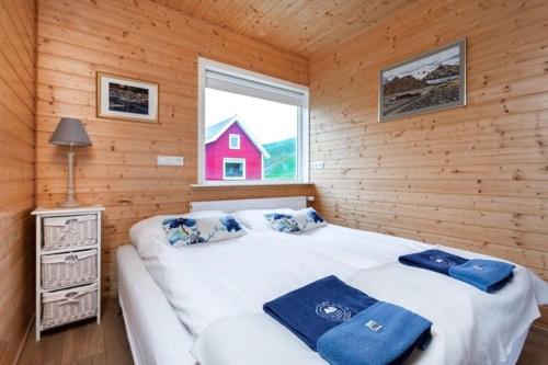 Eskifjörður美吉里度假屋的小木屋内一间卧室,配有一张大床