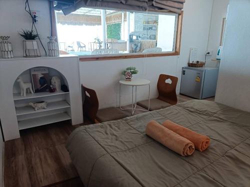 南芭堤雅Chuencheewa Resort的一间卧室设有一张床、一个窗口和一张桌子