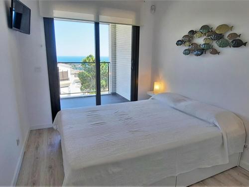 兰卡Apartamento Llançà, 1 dormitorio, 4 personas - ES-170-5的白色的卧室设有一张大床和一个大窗户