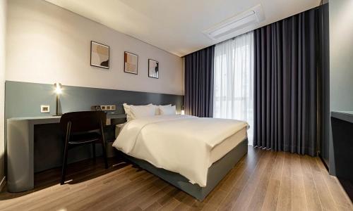 浦项Pohang Hotel Noblion的酒店的客房 - 带1张床、1张桌子、1张床和1张床