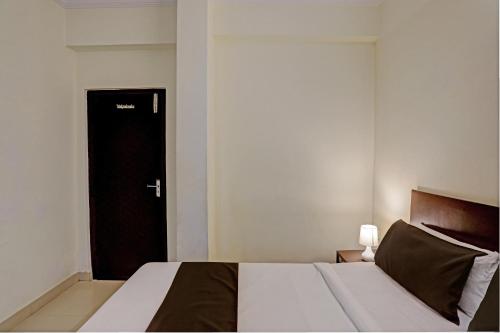 海得拉巴OYO Flagship 35467 Shiridi Residency Near Birla Mandir的一间卧室设有一张床和一个黑色的门