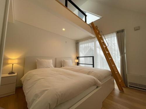RankoshiNiseko STREAM Villas的卧室配有一张带梯子的白色大床