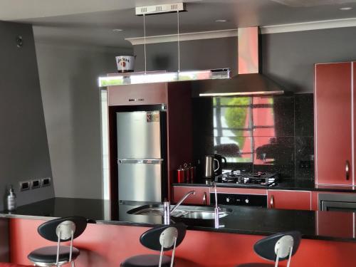 马丁伯勒马丁博勒德藤26号度假屋的厨房配有黑色台面和红色橱柜