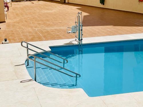 多列毛利诺斯Luxury loft with a pool in the centre的游泳池旁设有金属楼梯栏杆