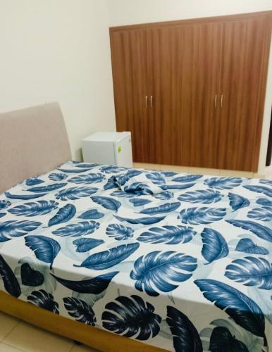 迪拜Blessing house的一间卧室配有一张带蓝白色毯子的床