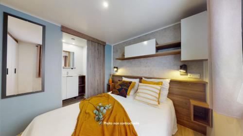 拉帕尔米雷Camping Officiel Siblu Bonne Anse Plage的一间卧室配有一张带黄色床单的大床
