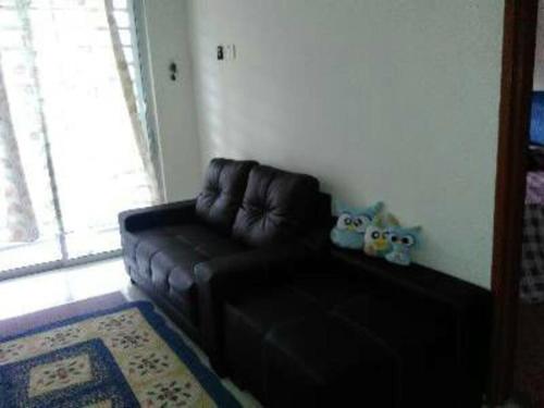 关丹AD Homestay Kuantan的客厅里设有一张黑色皮沙发,配有窗户