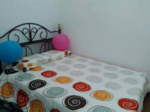 关丹AD Homestay Kuantan的一张带波卡圆点床单和气球的床