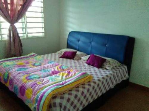 关丹AD Homestay Kuantan的卧室里一张带蓝色床头板的床