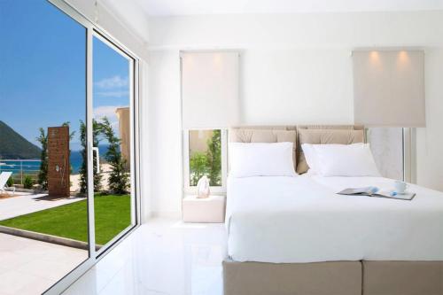 瓦西利基OFF White Villas的卧室设有白色的床和大窗户