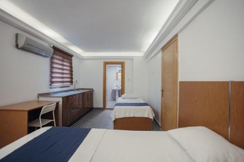 伊兹密尔Deniz Pansiyon的客房设有两张床、一张桌子和一个水槽
