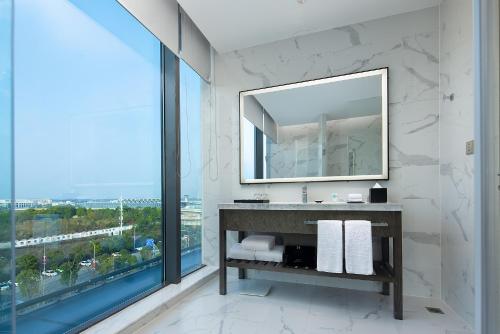 长沙长沙机场凯悦嘉轩酒店的一间带镜子和大窗户的浴室