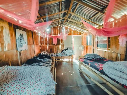索拉哈Pemsee's Tree Town的配有两张床和粉红色窗帘的房间