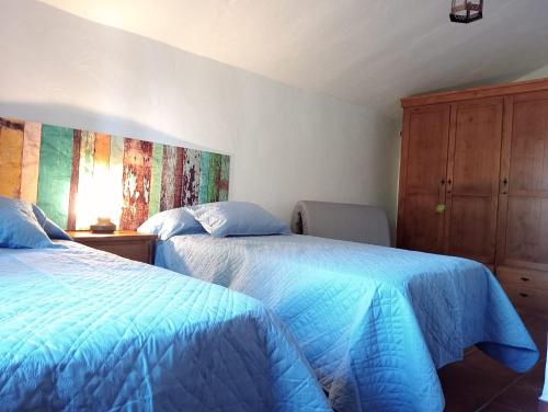 内尔哈Villa Aguacate的一间卧室设有两张床和木制橱柜