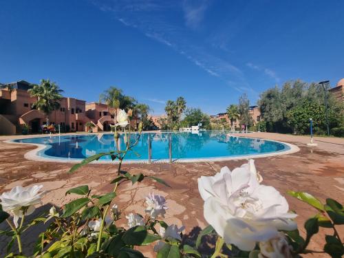 马拉喀什La Perle de Marrakech by Atlas Golf Resort的前面有一个白色花的游泳池