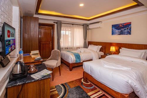 加德满都Darbar Heritage Inn的酒店客房设有两张床和电视。