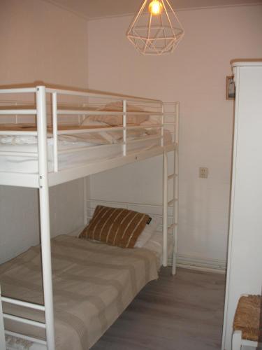 海边的艾格蒙特Sea的一间卧室配有两张双层床和一盏灯。