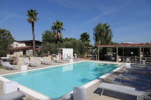 普罗斯西托角Giardini Sausari Residence的一个带躺椅的游泳池,一个度假村