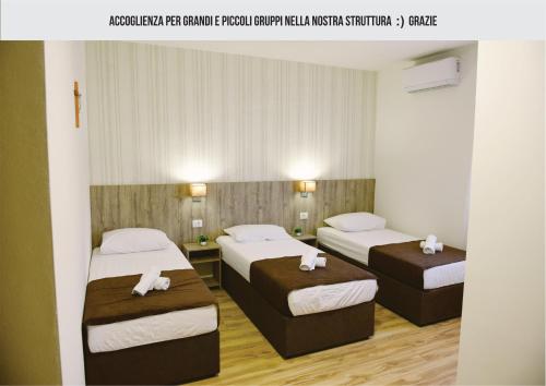 默主歌耶Mica Medjugorje的两张位于酒店客房的床,配有毛巾