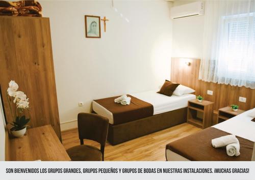 默主歌耶Mica Medjugorje的酒店客房设有两张床和一张桌子。