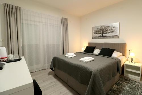 新格拉迪什卡Apartmani i sobe Laganini的一间卧室配有一张床,上面有两条毛巾