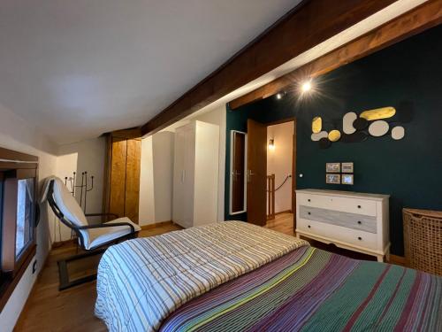 波泰皮莫朗Maison village proche Andorre et stations de ski的一间卧室配有一张床和一把椅子