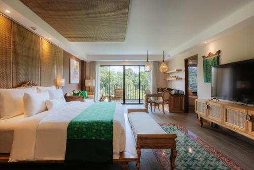 乌布Horison Ume Suites & Villas的一间卧室配有一张大床和电视
