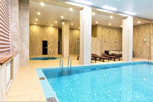 阿克套MIRAMAR Apart Hotel & SPA的一座配有桌椅的酒店游泳池