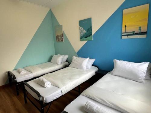 梳邦再也Serene Landed Endlot House Subang Jaya的拥有蓝色和白色墙壁的客房内的三张床