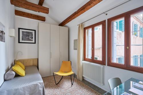 威尼斯Cà Boldo Terrace 2.0的一间卧室配有一张床和一张黄色椅子