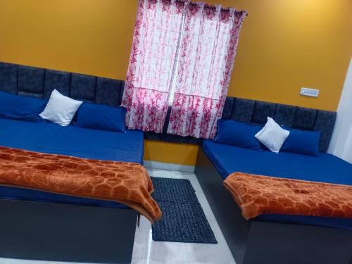乌贾因JAI BHOLE HOME STAY的客房设有两张床和窗户。