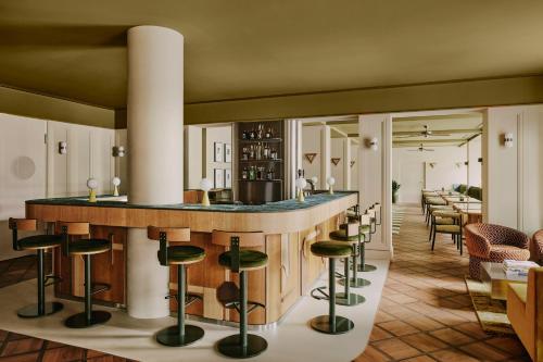 苏黎世Locke am Platz Zurich的餐厅内带绿色凳子的酒吧