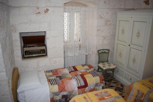 洛科罗通多trulli Annina的卧室配有一张床,墙上配有电视。