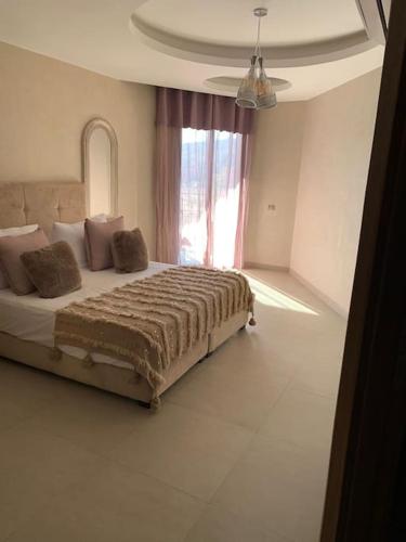 马拉喀什Appartement neuf climatisé, centre Marrakech.的一间卧室设有一张大床和窗户